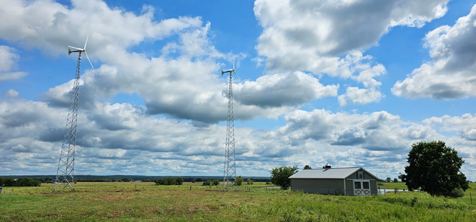 A wind turbine on a farm with a cloudy sky in the background