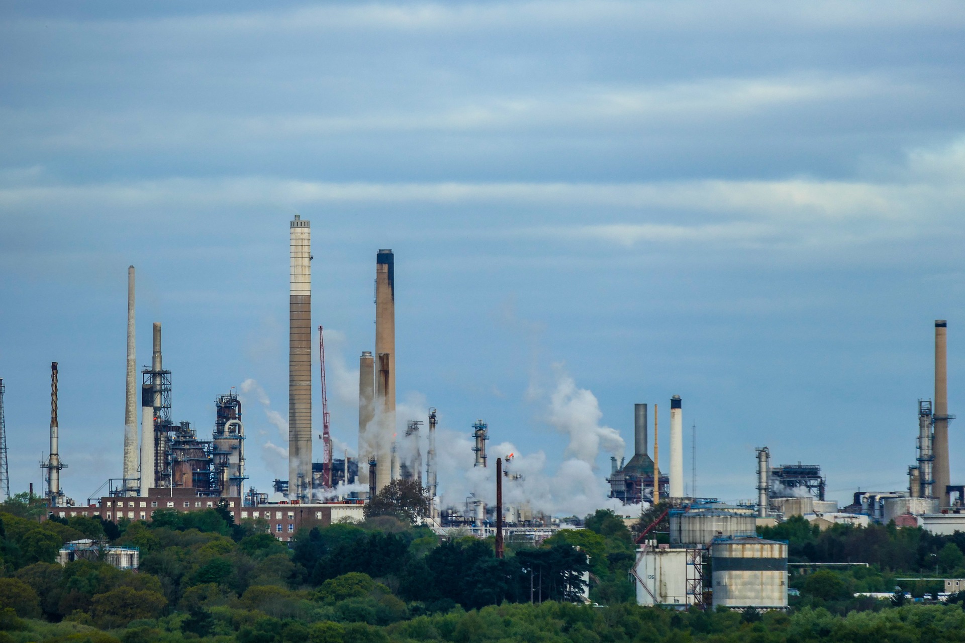 Smoke rises from a refinery and drifts into the atmosphere.