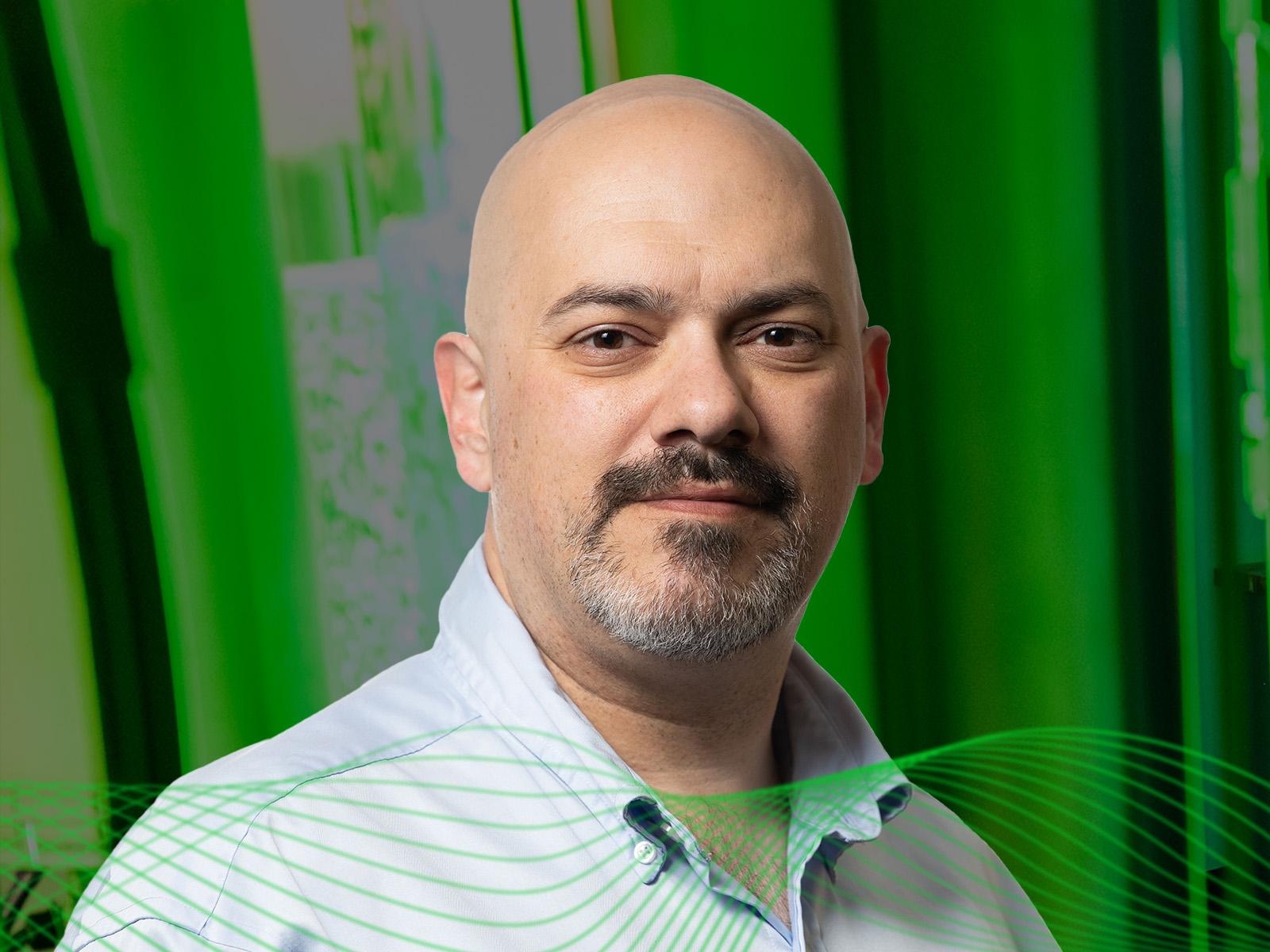 Doug Nordwall wearing a collared shirt in front of a green background