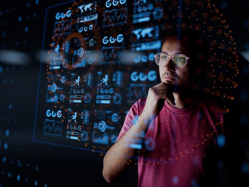 Analyst looks at the dashboard with graphs and charts.
