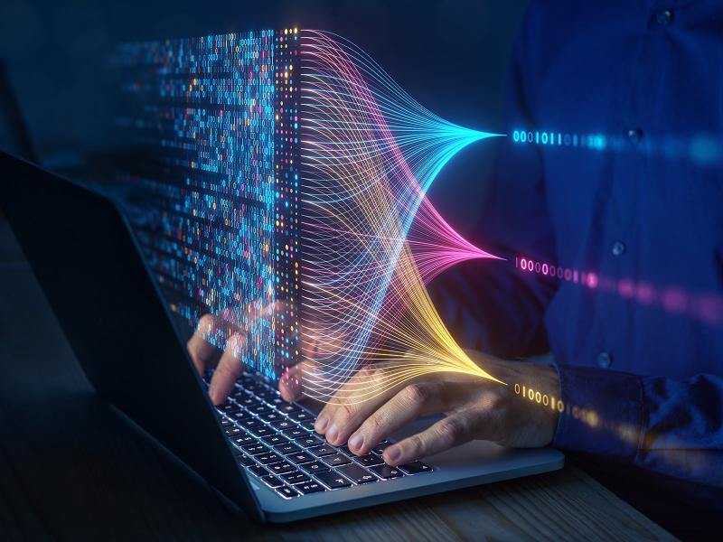 Image of numbers superimposed over hands typing on a laptop computer