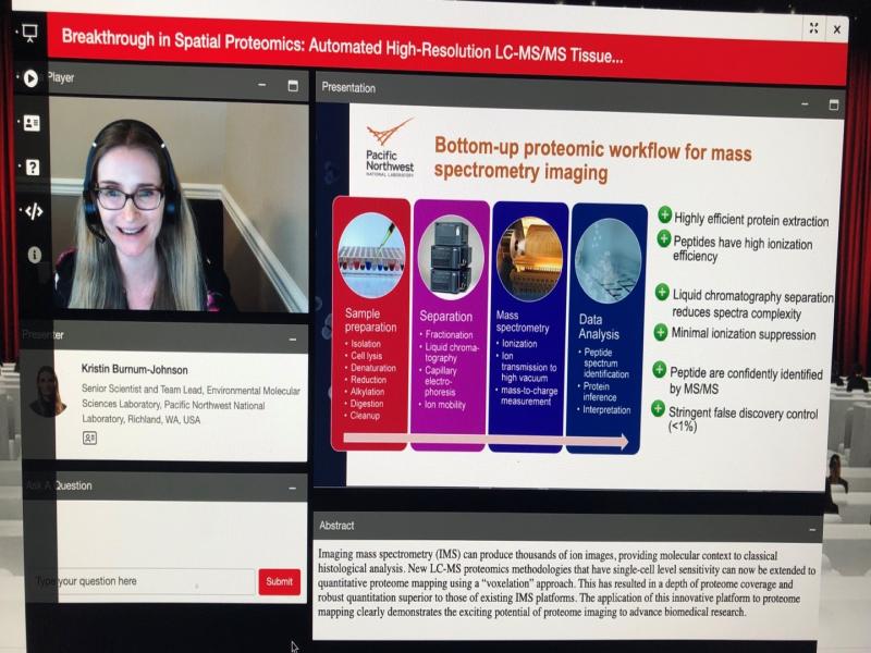 woman wearing a headset speaks on the left and a presentation image is on the right.