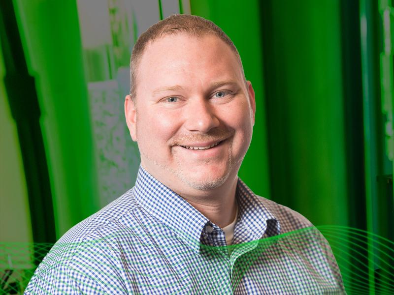 Thomas Edgar wearing a collared shirt in front of a green background